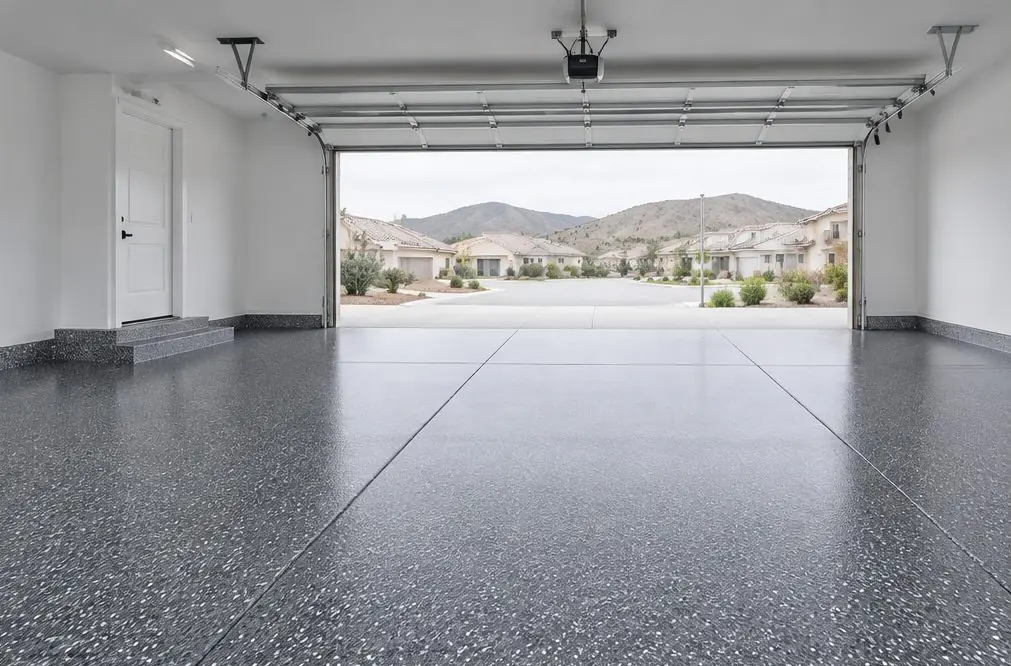 Illustration: a bright three-car garage in a large Murrieta home with a glossy tan, brown and white flake floor, a coated step at the house door and the doors open to afternoon sun